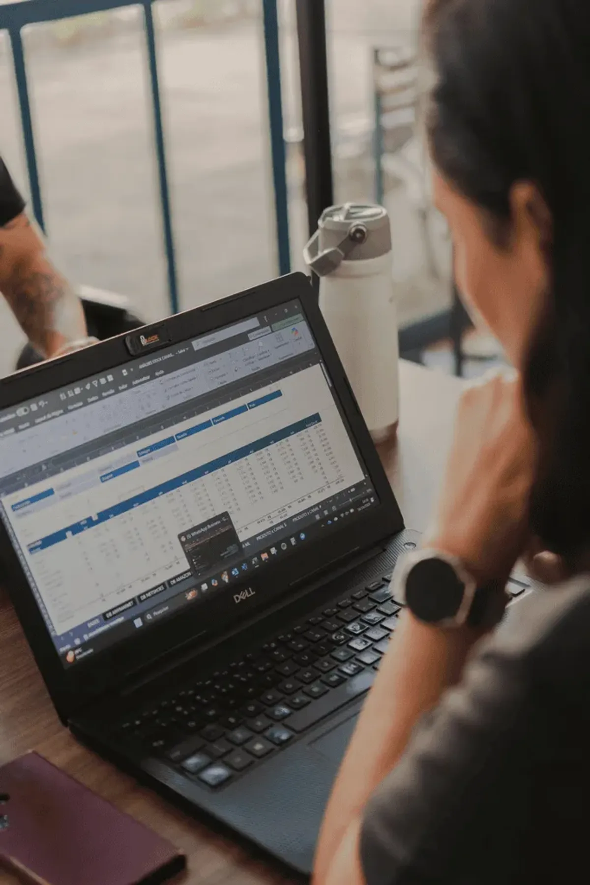 Woman reads spreadsheets on laptop
